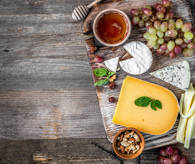 Cheese plate served with wine, nuts and honey 