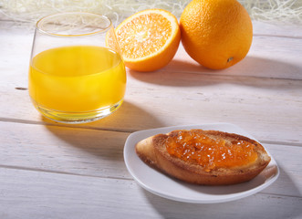 Morning Breakfast set with orange jam on bread toast and juice in glass.