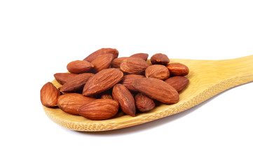 Almonds in a wooden spoon isolated on white background. Close-up.