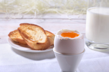 Morning Breakfast set with egg, orange jam on bread toast and milk in glass.