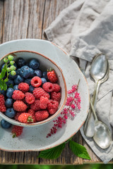 Tasty blueberries and raspberries on old wooden rustic table