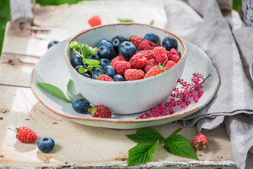 Healthy blueberries and raspberries on old wooden rustic table