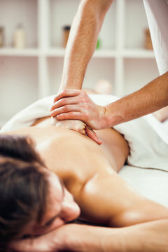 Young man is having back massage on spa treatment.