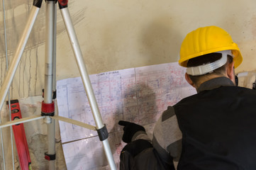 HVAC worker sitting on the and fingering to the working plan