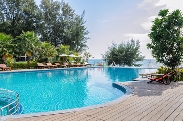 Sea view swimming pool with sunbed and white umbrella
