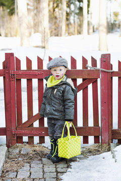 Boy with bag standing at gate