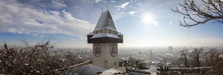 panorama of the  schlossberg hill with the landmark clocktower uhrturm in winter, graz, austria