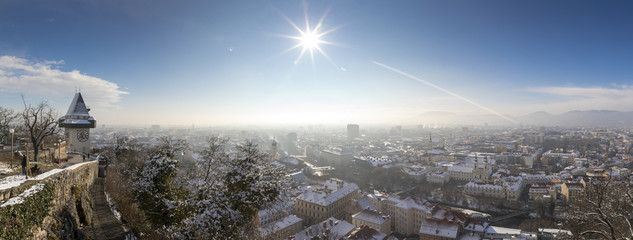 panorama of the  schlossberg hill with the landmark clocktower uhrturm in winter, graz, austria