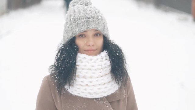 portrait of beautiful young woman in hat at winter snowy day outdoors