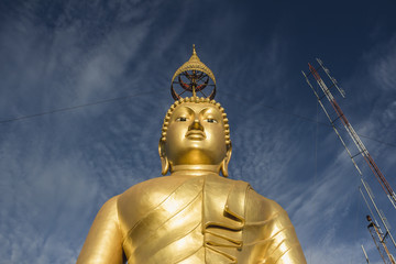 Big gold Buddha statue at the sunrise in Tiger Cave Temple in Krabi province, Thailand