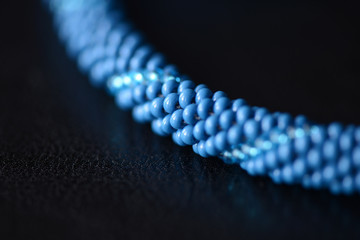 Blue bead crochet necklace on a dark background close up