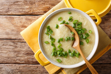 Homemade diet egg soup with fresh chives in a bowl close-up. horizontal top view