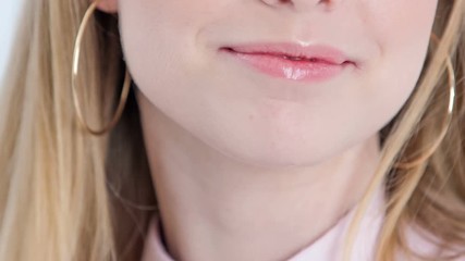 A young woman flicks her hair back. She is checking her new make up look in the mirror.