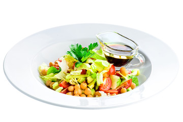 Vegetarian salad with tomato, avocado, salad and soy sauce in a white plate isolated on white background. Top view, flat lay