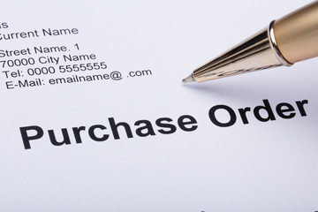 Person Hand Filling A Purchase Order Form