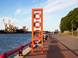 Fototapeta na wymiar Stend of lifebuoys on coastline.