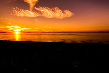 Silhouette of sunset beach, landscape of sky with orange sun going in to the sea