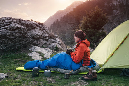 Female Traveler In A Sleeping Bag Near The Tent In The Mountains, Turkey