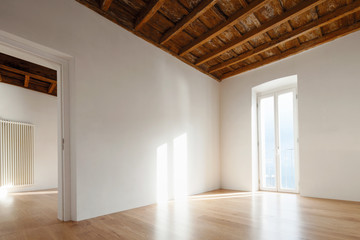 Empty room with large windows and antique beams