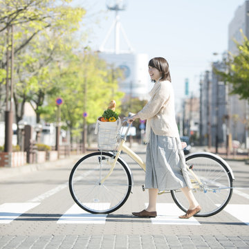 自転車で買い物をする女性