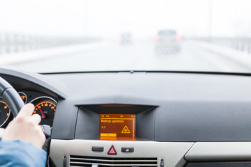Ostrzeżenie o śliskiej nawierzchni na wyświetlaczu samochodowym, widok z wnętrza © lukszczepanski