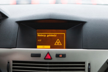 Ostrzeżenie o śliskiej nawierzchni na wyświetlaczu samochodowym, widok z wnętrza © lukszczepanski