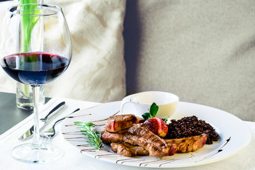Grilled Rack of Lamb served in a plate with rosemary sauce and black rice, a dish in a restaurant
