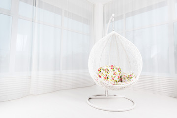 White round chair with flowers in a light large living room. Concept of wedding, marriage