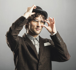 Man in retro clothes raising his hat and glasses.
