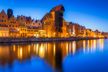 Naklejka premium Gdansk at night with historic port crane reflected in Motlawa river, Poland