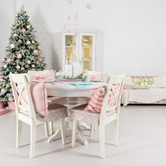 Beautiful Christmas decorated light living room with a Christmas tree, table and chairs. Concept of winter holidays and Happy New Year