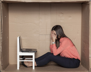 business woman hides her head in her hands, her company goes bankrupt