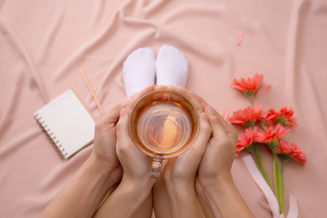 Love or valentine's day concept. Womans and mens hands holding hot cup of tea