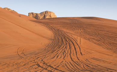 Fototapeta na wymiar tyre tracks inthe desert at sunrise