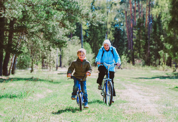 Fototapeta premium active senior grandmother with grandson riding bikes in nature