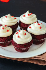 Red velvet cupcakes with cream cheese frosting on a white plate