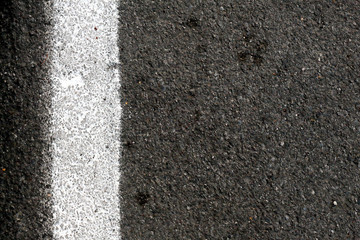 Fototapeta premium Closeup of road surface with white paint line, vertical.