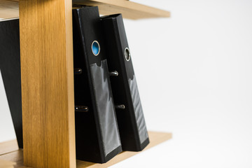 close up view of folders with documents on wooden bookshelf