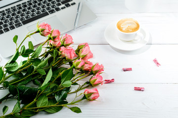 Have A Nice Day concept. Cup of coffee with fresh beautiful flowers and laptop on light table.