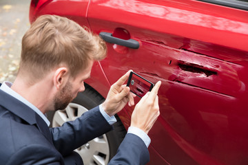 Person Taking Picture Of Damaged Car