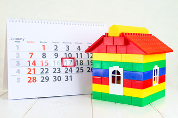 January 17th. Day 17 of month on white calendar and a colorful toy house. Day of childrens inventions
