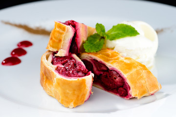 Sliced homemade delicious cherry strudel on a white plate