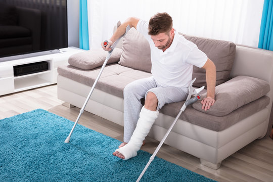 Man With Broken Leg Getting Up From Sofa