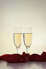 Two glasses with champagne and a red ribbon