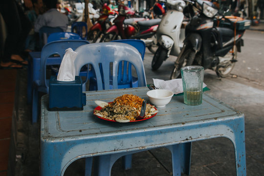 Vietnamese street food on dirty blue plastic table.