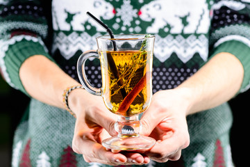 Man holding hot Amaro cocktail with apple juice and cinnamon