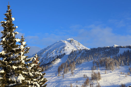 Fototapeta Montgenevre. Winter landscape in French Alps. Mountain peaks and ski slopes on snow-covered hillside