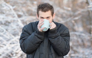 Man drink hot tea in the nature a winter's day