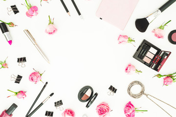 Female workspace with cosmetics, accessories and pink roses on white background. Top view. Flat lay. Beauty blog