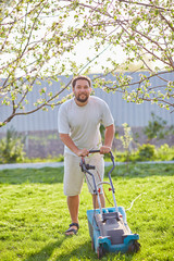 low angle view of young man mowing lawn
